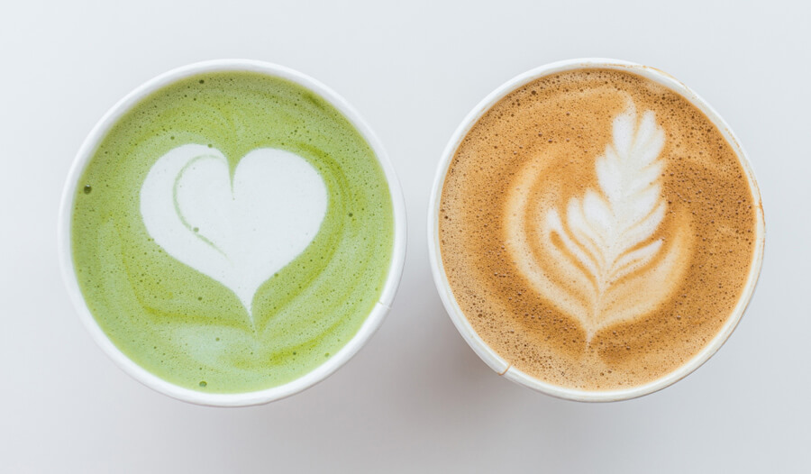 An image of 2 cups on a white background. One cup is full of matcha, and the other is filled with coffee.