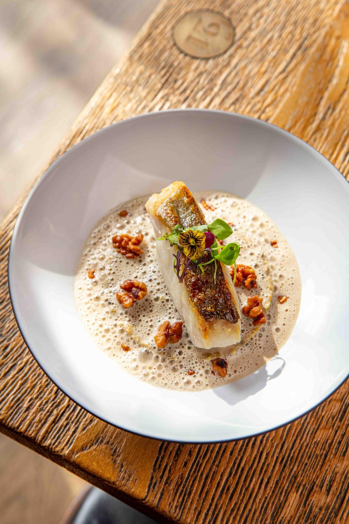 Le poisson du jour, fondue de poireaux au lard paysan, fumet monté au beurre de noix