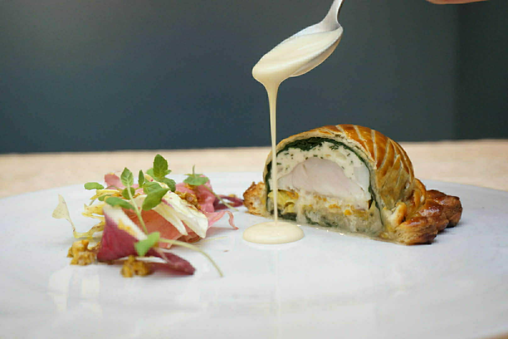 Phithiviers de bar, yuzu,poireaux grillés, chou pointu, radicchio, pistaches, sauce au Xérès